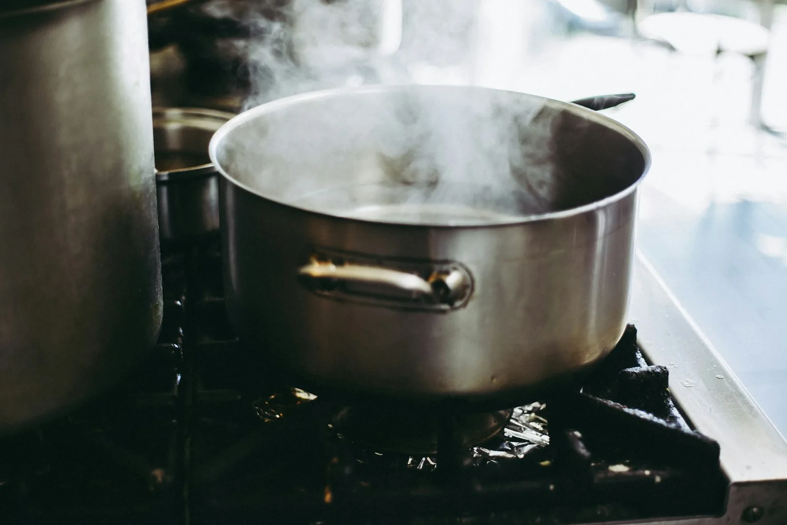 A large steel stock pot steaming on the stove