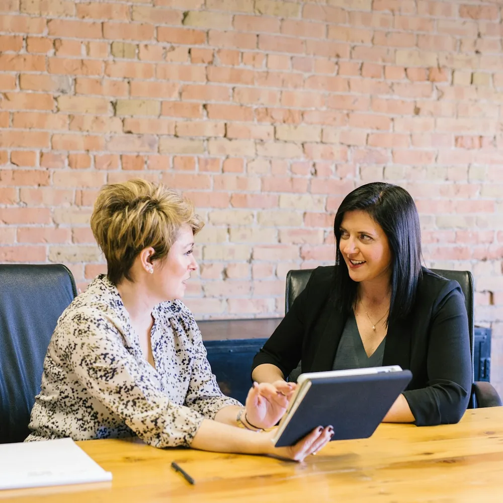 Attorney and client talking across a wooden table with a tablet