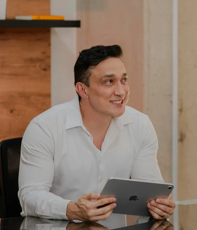 Portrait of Daniel Lin at his desk holding a tablet
