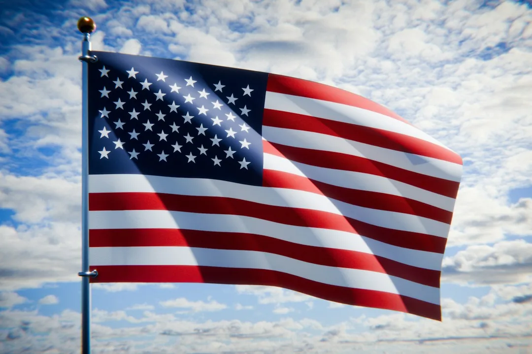 American flag waving against a bright sky