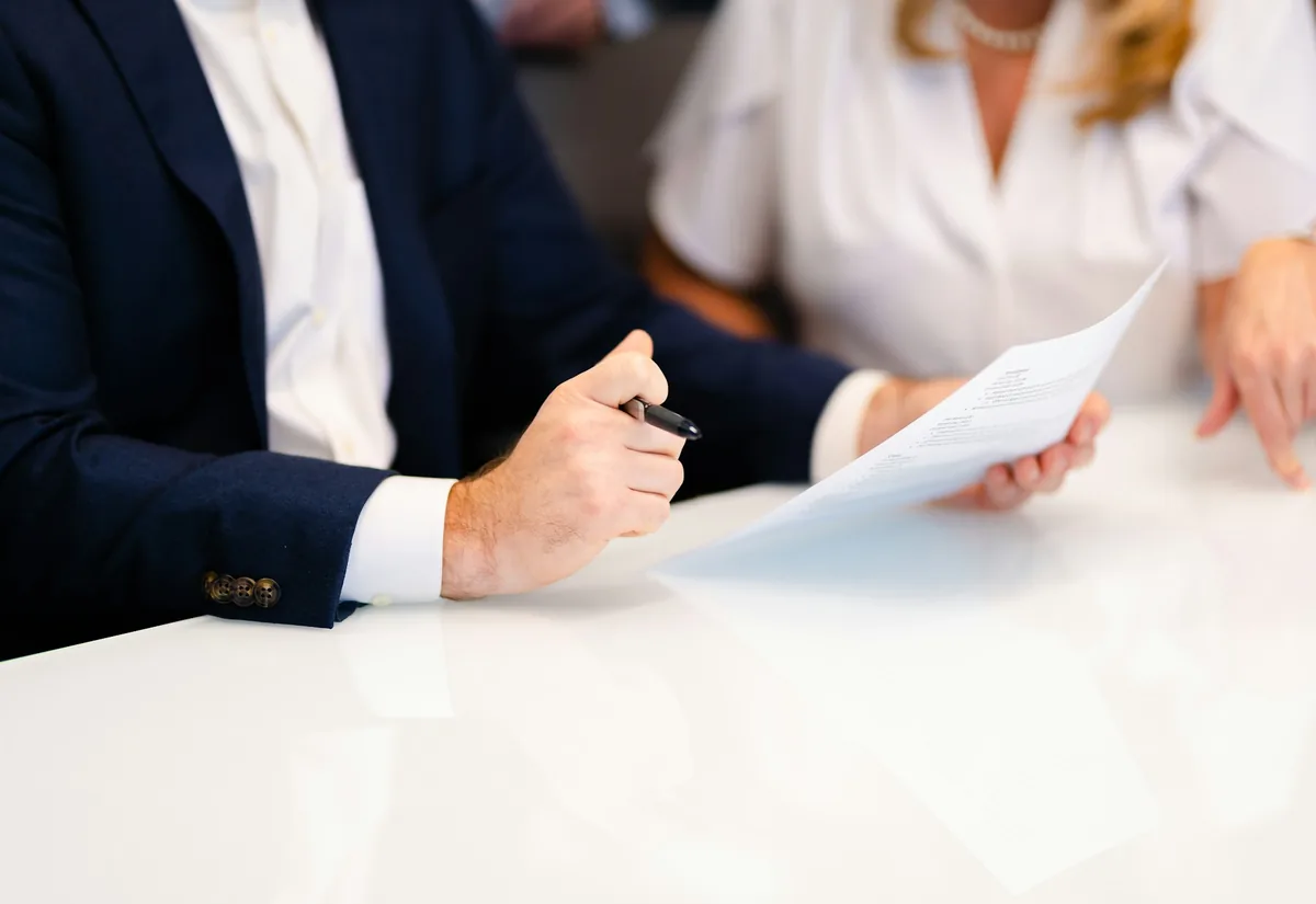 Attorney pointing to a line on a document while a client reads along