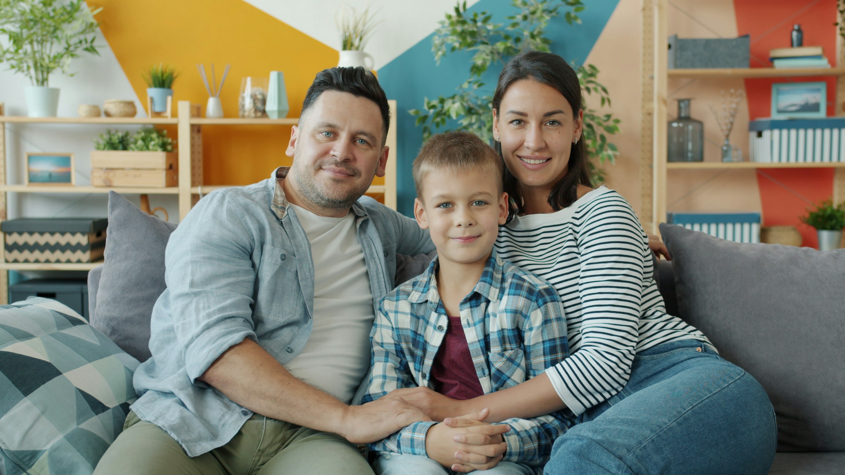 A family smiling together on their sofa
