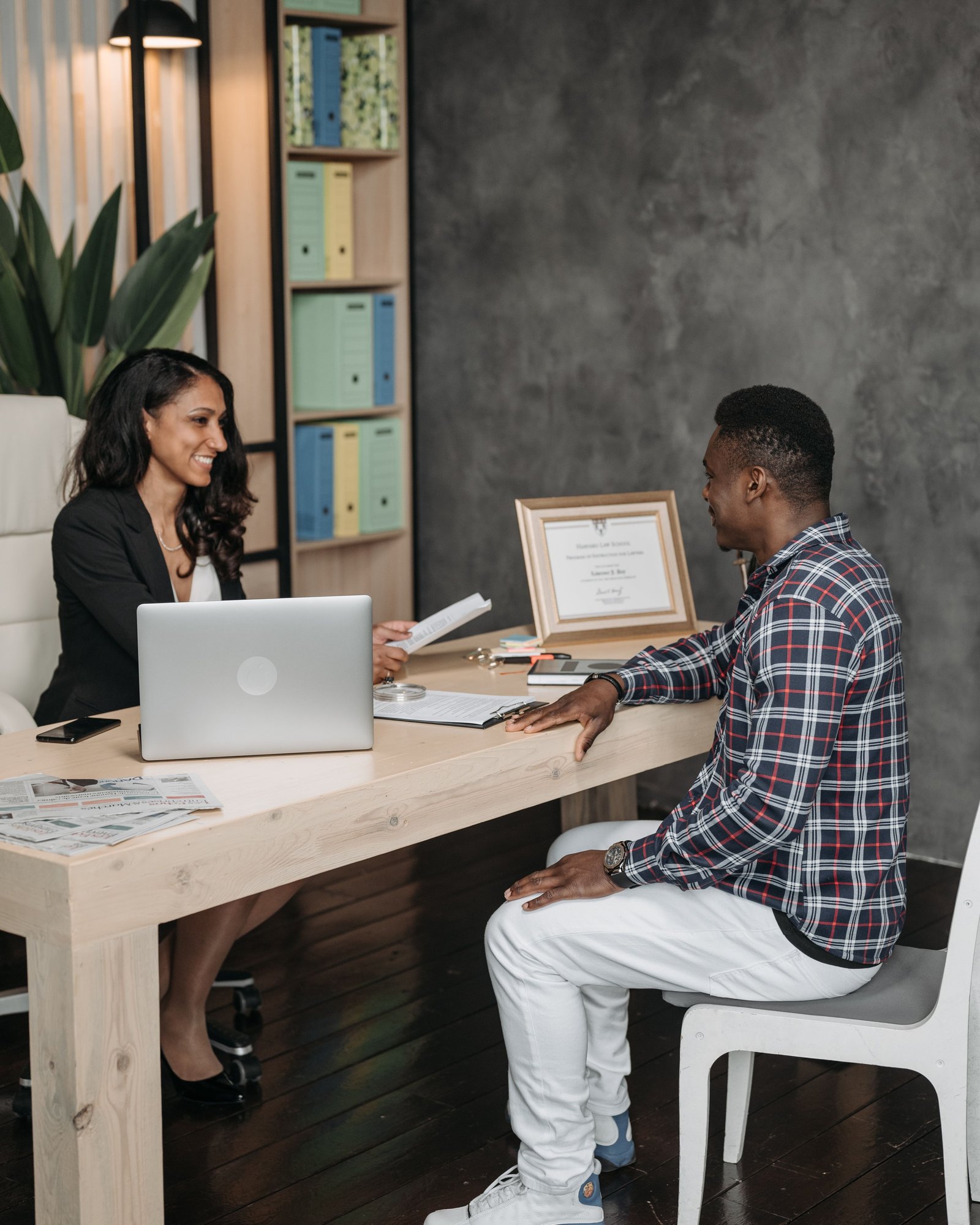 People carefully organizing and reviewing documents at a desk