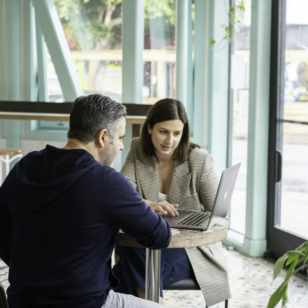 A solicitor going through a laptop with a father at a bright window table