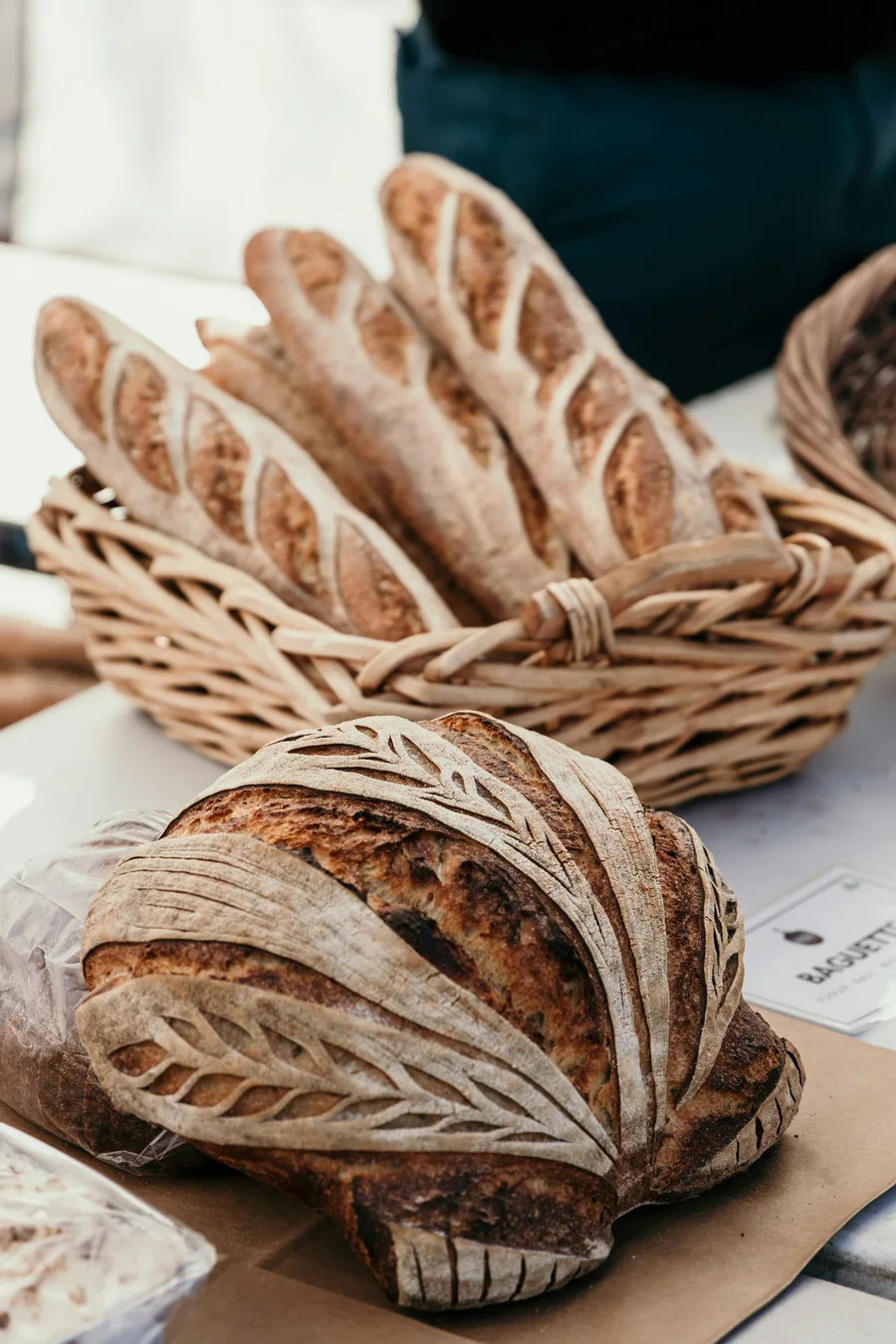 Round sourdough loaves with floured, scored crusts