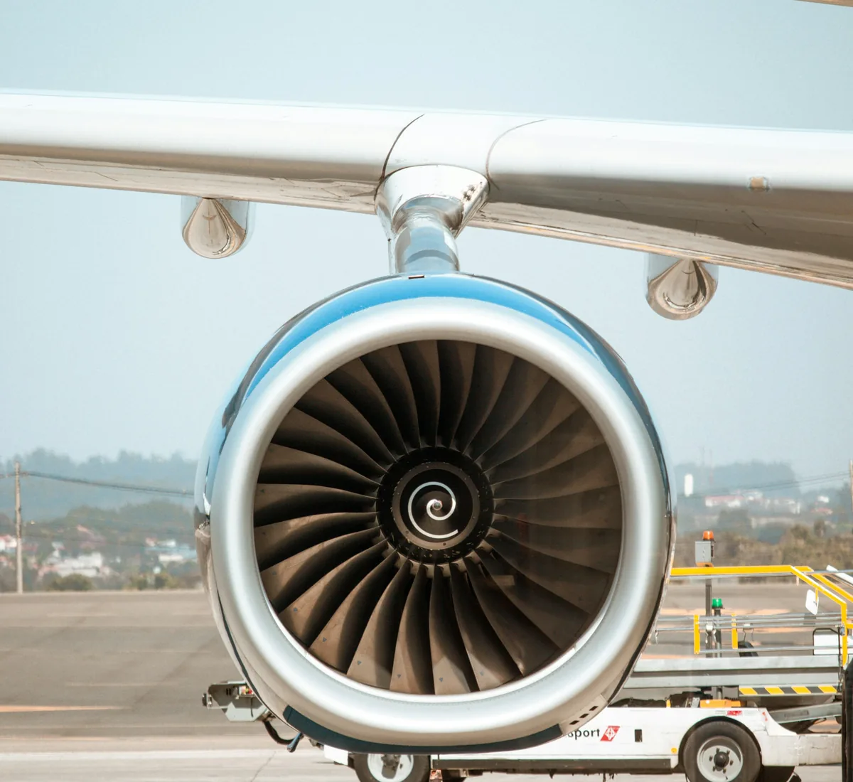 Jet engine fan under an airliner wing at the gate