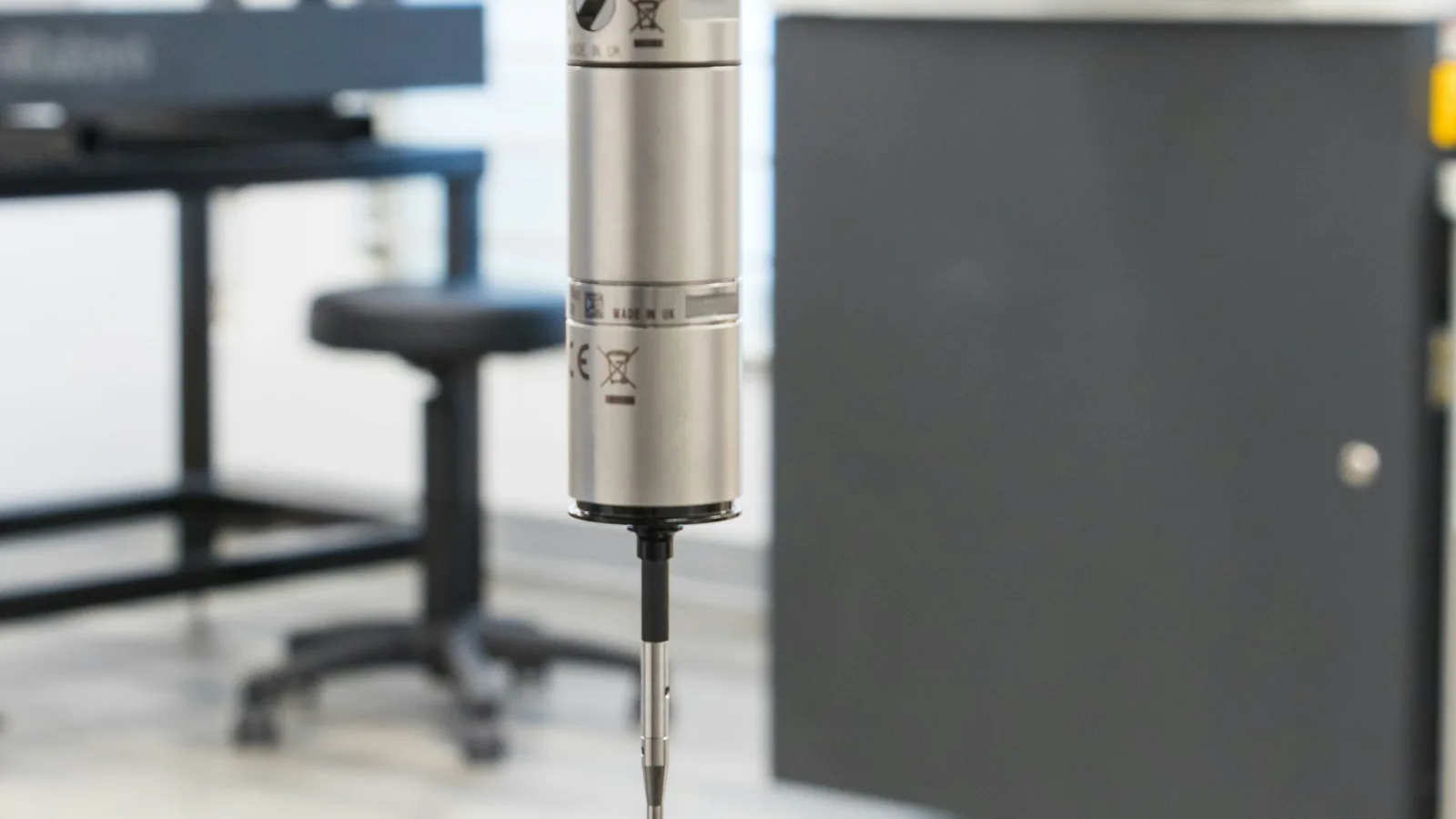 CMM probe in a bright, quiet inspection lab