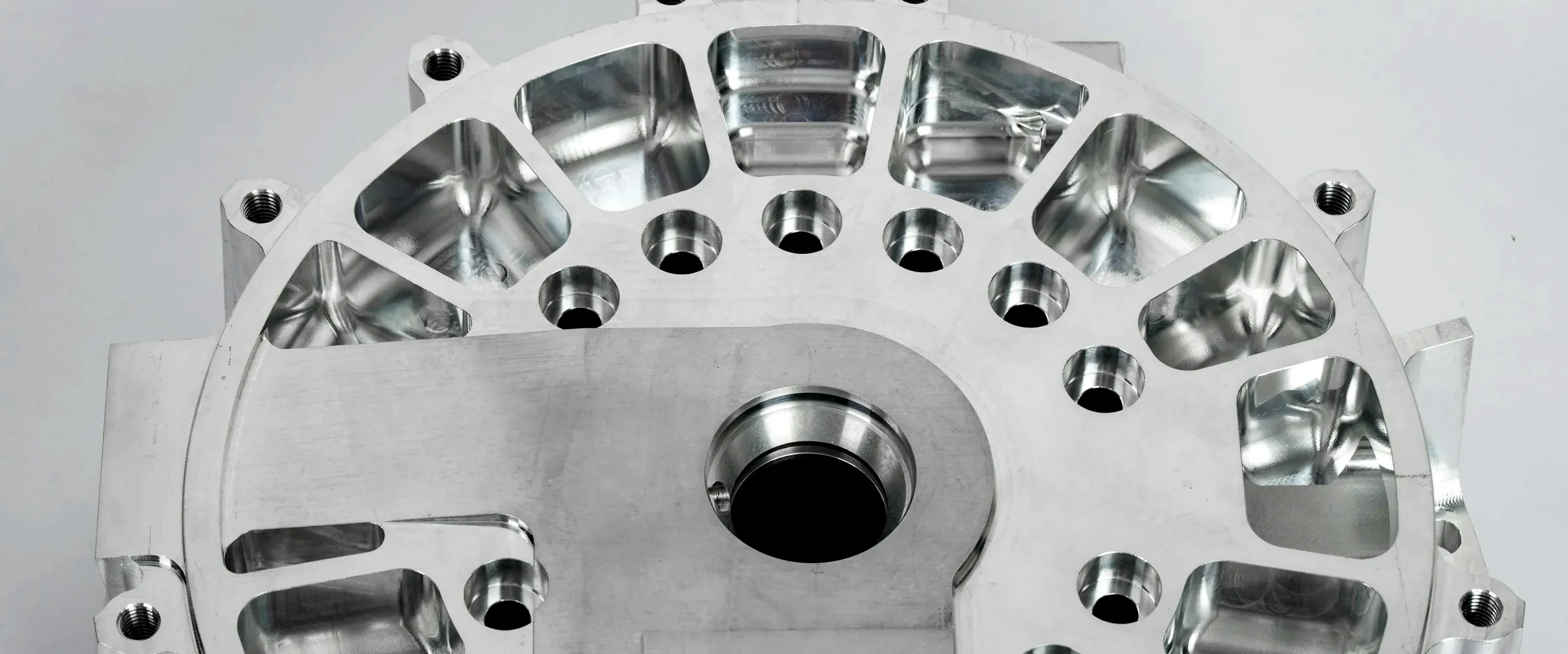 Machined aluminium housing with a ring of pockets, bolt lugs and a precision centre bore