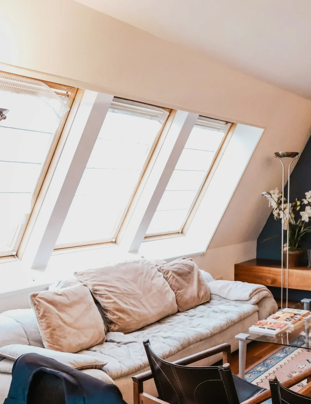 A finished loft bedroom with a roof window and a sloping white ceiling