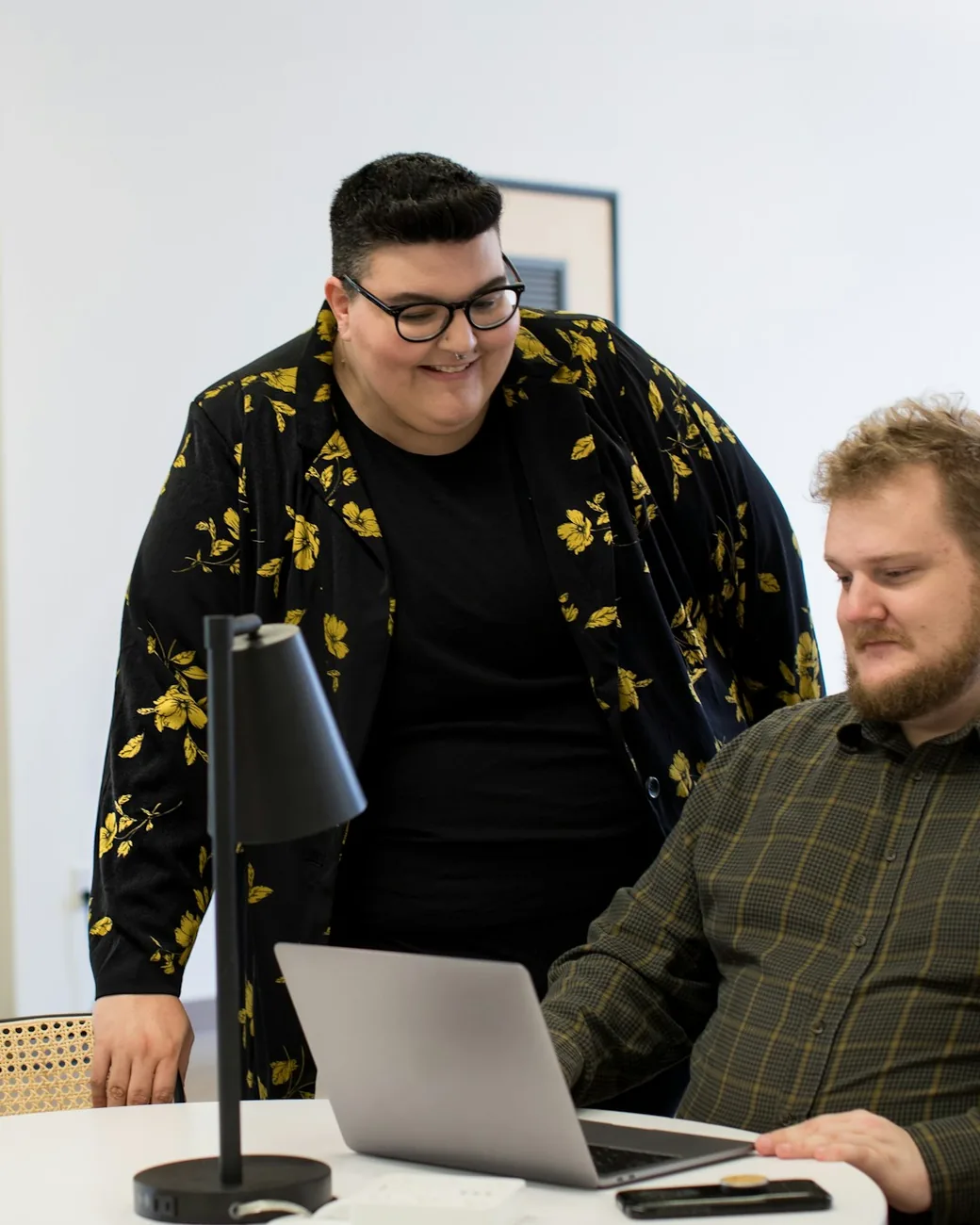 A Fieldnote writer reviewing a founder's investor narrative on a laptop with a colleague
