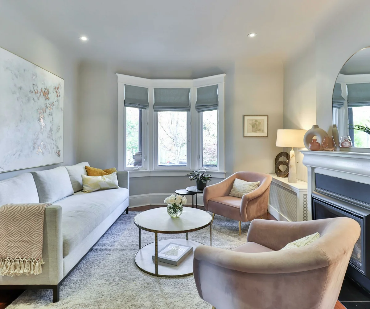 Bright period living room with a tall sash window, cornicing and a fireplace