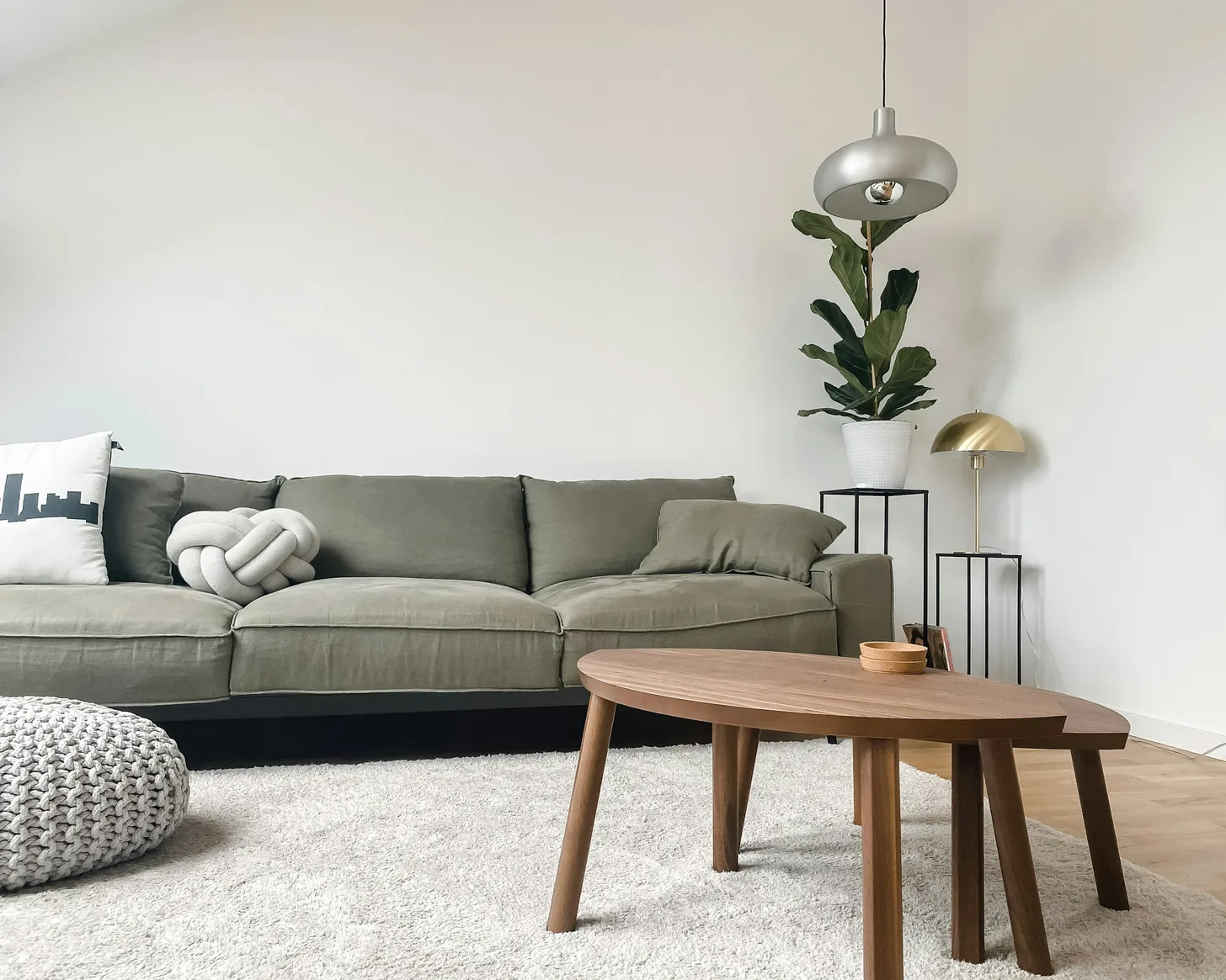 Klitvej House living room: sage sofa, oak table and white walls in daylight