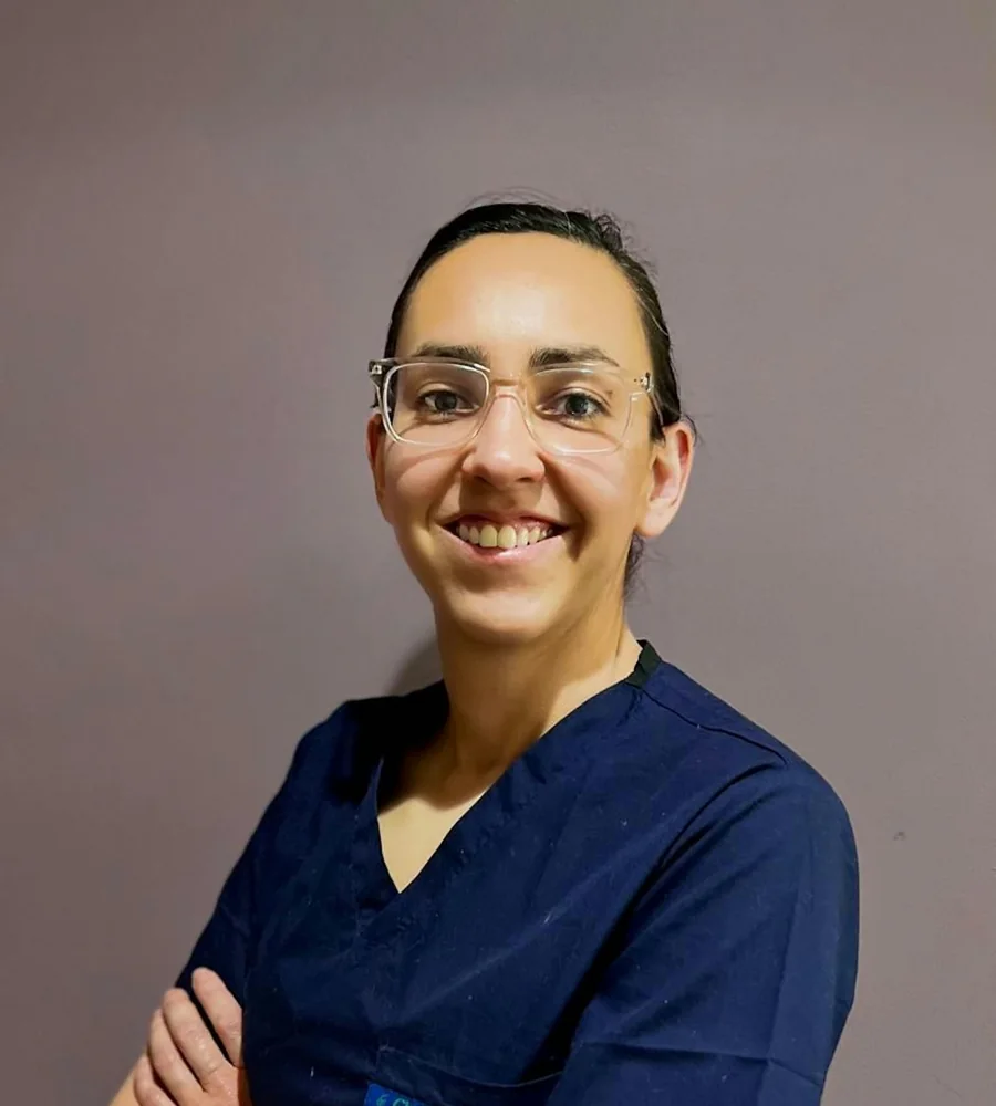 Ana Ruiz, physiotherapist, in navy scrubs with her arms folded