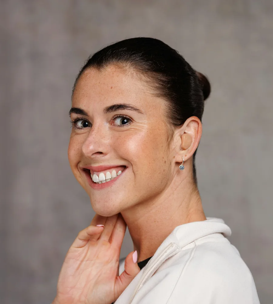 Leah Carter, physiotherapist, smiling against a plain grey wall