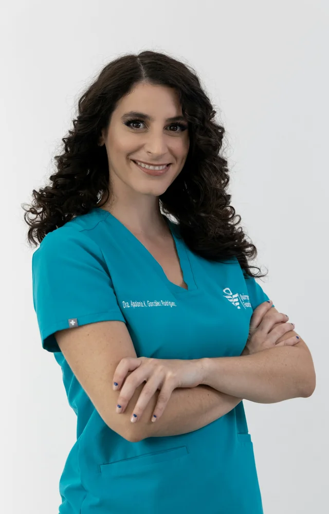 Smiling nurse in teal scrubs with her arms folded